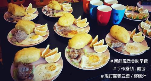 un montón de platos de comida con naranjas. en Huadong Homestay, en Taitung