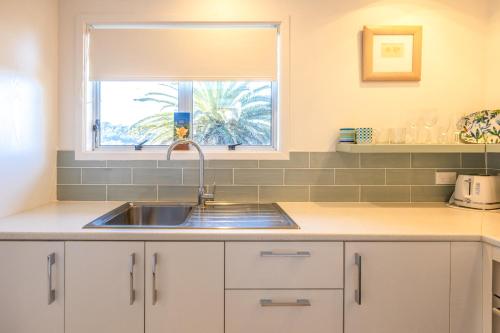 a kitchen with a sink and a window at Waiheke Island Motel in Ostend