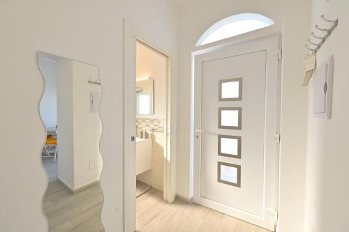 a hallway with white walls and an open door at La Perla Sul Mare in Forio d'Ischia