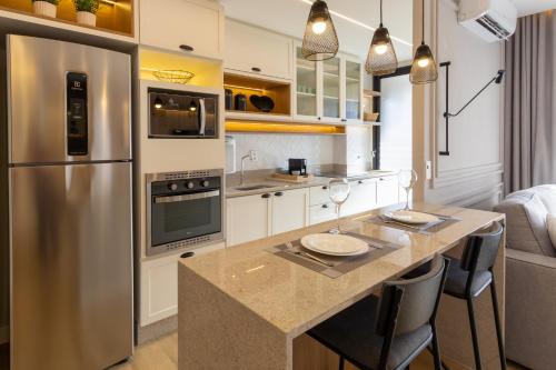 a kitchen with a stainless steel refrigerator and a counter at Elegante Apartamento no Cambuí in Campinas