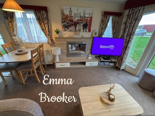 a living room with a tv and a dining table at Lapwing 32 Cayton Bay in Scarborough