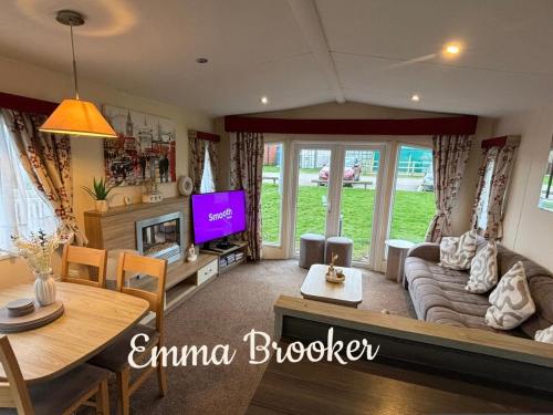 a living room with a couch and a tv at Lapwing 32 Cayton Bay in Scarborough