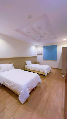a room with two beds and a blue wall at شاليهات واحة لافندر in Taif