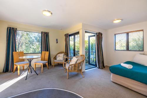 a bedroom with a bed and a table and chairs at Waiheke Island Motel in Ostend