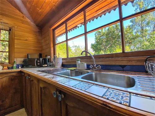 a kitchen with a large sink in a cabin at Refugios de la Montaña in San José de Maipo
