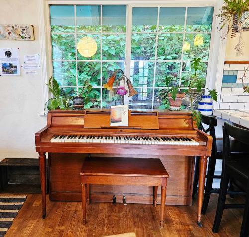 a piano sitting in a room with a window at Sky Cabin in Aptos