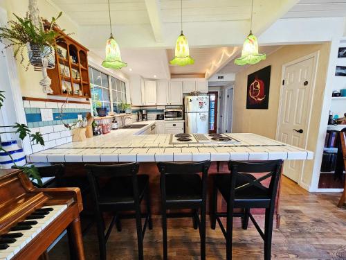 a kitchen with a bar with chairs and a piano at Sky Cabin in Aptos