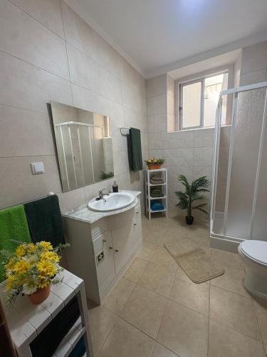 a bathroom with a sink and a shower and a toilet at Casa São Marcos in Peniche