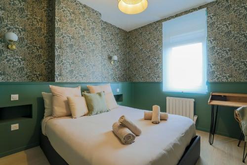 a bedroom with a bed with towels on it at La Canopée - Bohemian - chic apartment in Lens