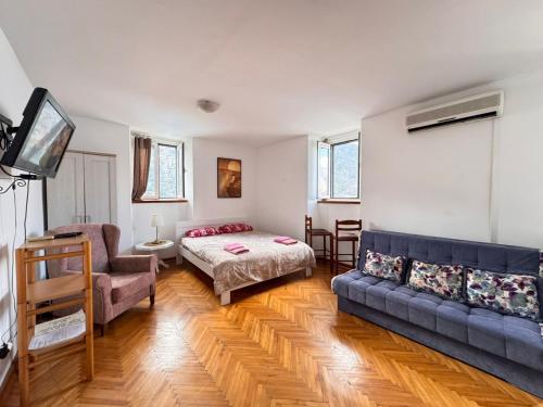 a living room with a couch and a bed at Villa Kamena in Kotor