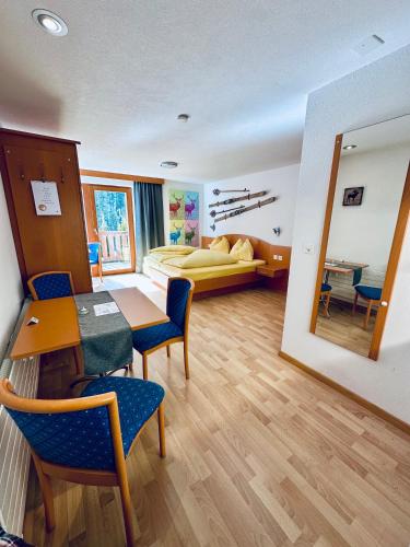 a room with a bed and a table and chairs at Apart Jil-Marie Studio 7 in Samnaun