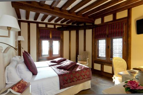 a bedroom with a large bed and a large window at Auberge Saint Pierre in Le Mont Saint Michel