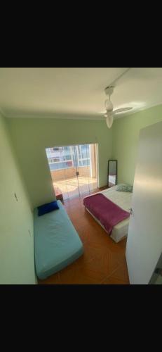 a room with two beds and a ceiling at Residêncial Allah in Peruíbe