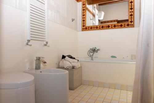 a bathroom with a toilet and a tub and a sink at Maestosa Maison della Cattedrale, 3 piani storici tutti per voi! in Sutri
