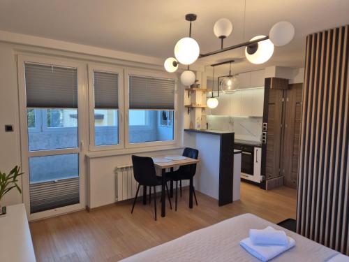 a room with a table and a kitchen with windows at OffWysowa in Wysowa-Zdrój