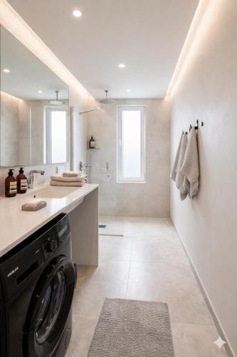a washing machine in a kitchen with a sink at Splash Suites with Private Pools in Nikiana