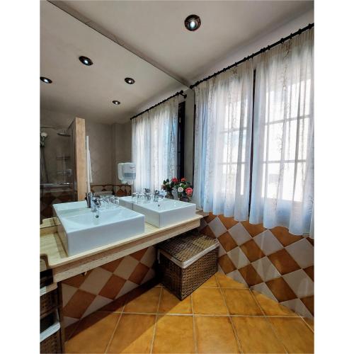 a bathroom with two sinks and a large window at Hotel Apartamento Marouco in A Guarda