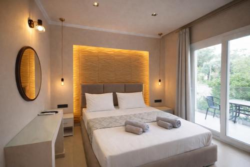 a bedroom with a bed with two towels on it at Adriolos Apartments in Liapades