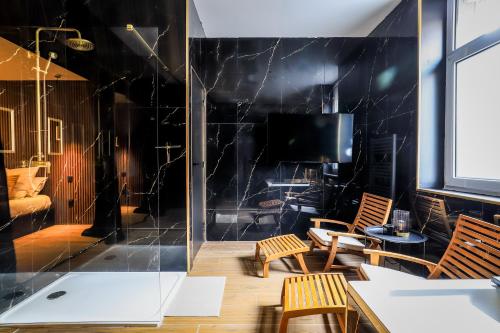 a room with a table and chairs and a tv at Golden Suite - Elegance - Private Spa Jacuzzi in Lens