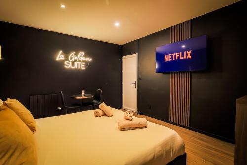 a bedroom with a bed and a tv on the wall at Golden Suite - Elegance - Private Spa Jacuzzi in Lens