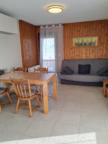 ein Wohnzimmer mit einem Holztisch und einem Sofa in der Unterkunft L'Autane in Saint-Léger-les-Mélèzes