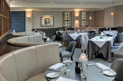 a restaurant with white tables and chairs and tablesearcher at Manor Hotel Solihull, BW Signature Collection in Bickenhill