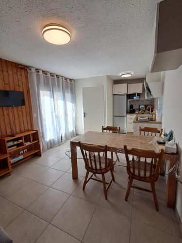 ein Wohnzimmer mit einem Holztisch und Stühlen in der Unterkunft L'Autane in Saint-Léger-les-Mélèzes