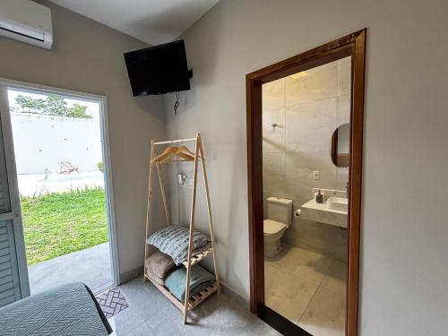 a bathroom with a mirror and a sink and a toilet at Suítes Brotas in Brotas