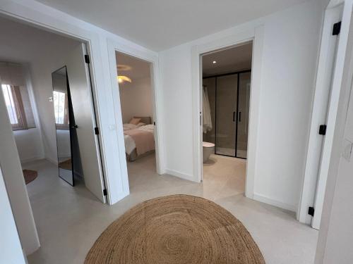 a white room with a bathroom with a bed and a rug at ALTEA LUXURY - Blue Pearl in Altea la Vieja