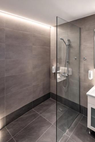 a shower with a glass door in a bathroom at Oasis Apartments & Rooms in Plakias