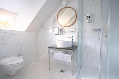 a white bathroom with a sink and a mirror at Das Schreder Hotel - Munich Free Parking in Munich