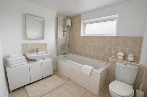 a bathroom with a sink and a tub and a toilet at Daisy House- Sleeps 7- Driveway Parking, Contractors, Fast Wifi and Smart TV in Oxford