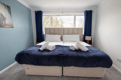 a bedroom with a large bed with a blue blanket at Daisy House- Sleeps 7- Driveway Parking, Contractors, Fast Wifi and Smart TV in Oxford