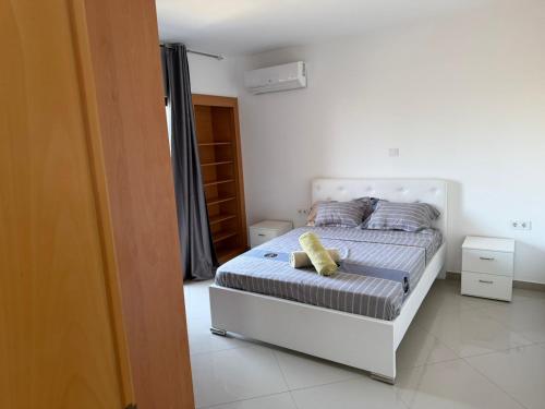 Un dormitorio con una cama con una almohada amarilla encima. en Morabeza, en Praia