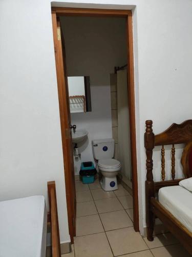 a bathroom with a toilet and a sink in a room at Hostal Jireh in Altagracia