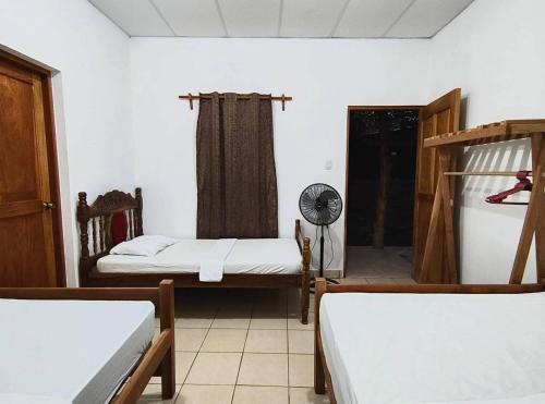 a room with two beds and a fan at Hostal Jireh in Altagracia