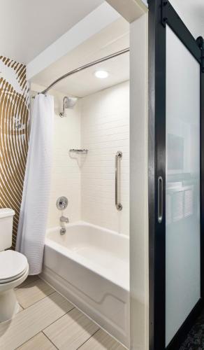 a bathroom with a white tub and a toilet at Renaissance Asheville Downtown Hotel in Asheville
