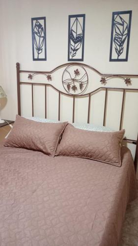 a bedroom with a bed with a wooden head board at Altos de la Villa House in Concepción del Uruguay
