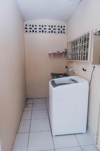 a small kitchen with a refrigerator and a tiled floor at Casa Celeste in Boa Vista