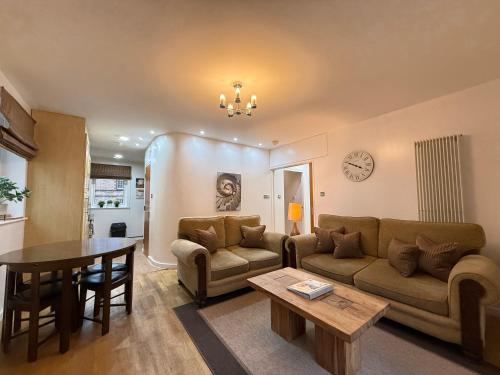 a living room with a couch and a table at Holyrood Apartment with parking & lift access in Edinburgh