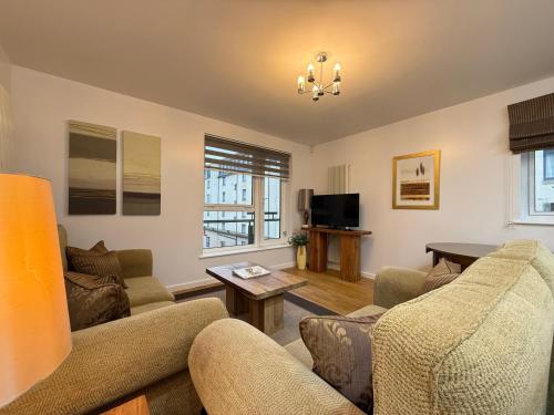 a living room with a couch and a table at Holyrood Apartment with parking & lift access in Edinburgh