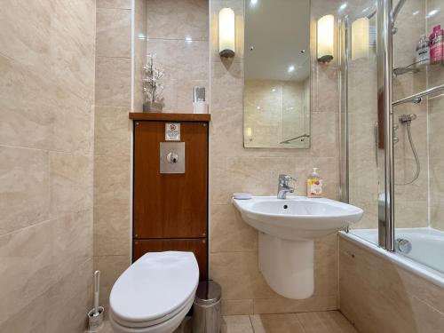 a bathroom with a toilet and a sink and a shower at Holyrood Apartment with parking & lift access in Edinburgh