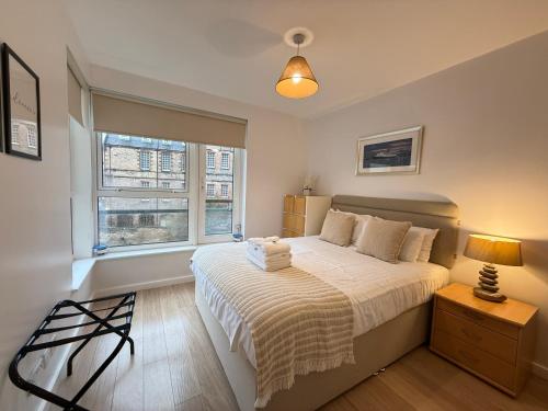 a bedroom with a bed and a window at Holyrood Apartment with parking & lift access in Edinburgh