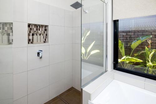 a bathroom with a shower with a window at Absolute Beach Front Home -Dogs, Surf, Relax, Bush in Kawana Waters