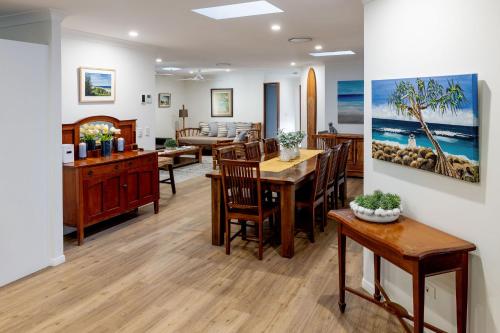 a dining room and living room with a table and chairs at Absolute Beach Front Home -Dogs, Surf, Relax, Bush in Kawana Waters