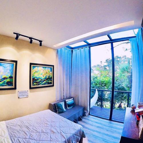 a bedroom with a bed and a large window at abot langit calatagan in Calatagan