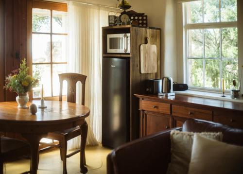 a kitchen with a table and a black refrigerator at Devlin's Cottage in Cape Bridgewater