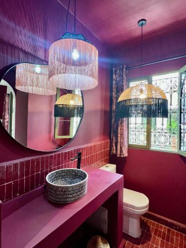 a purple bathroom with a sink and a mirror at Riad OUAR - Once Upon A Riad in Marrakesh