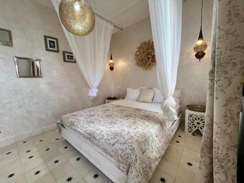 a bedroom with a bed in a room with curtains at Riad OUAR - Once Upon A Riad in Marrakesh