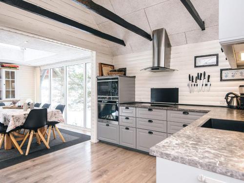 a kitchen with a table and a dining room at 4 star holiday home in Blåvand in Blåvand